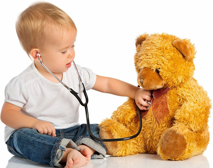 A baby is playing with a teddy bear