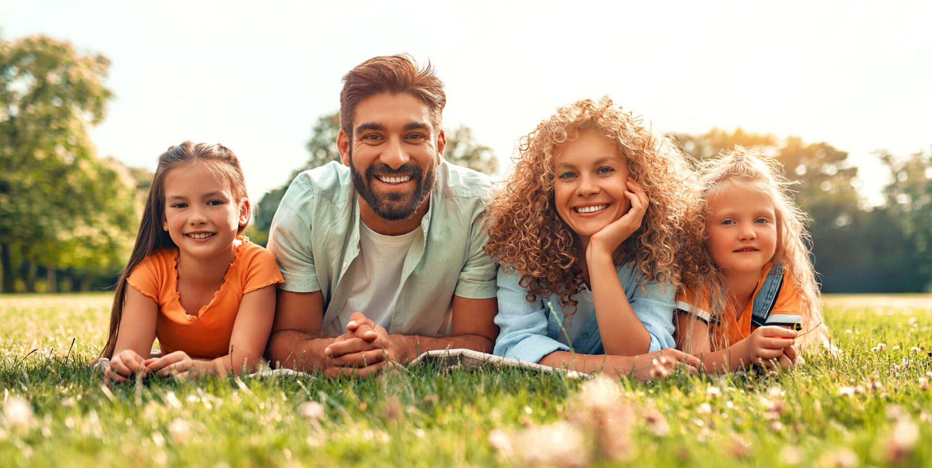 Happy,Young,Family,Dad,,Mom,And,Two,Daughters,Lying,On